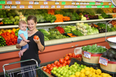 mother with baby picks produce